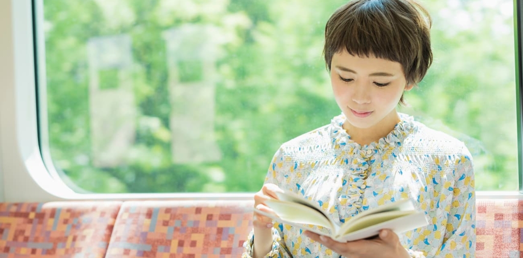電車で本を読む女